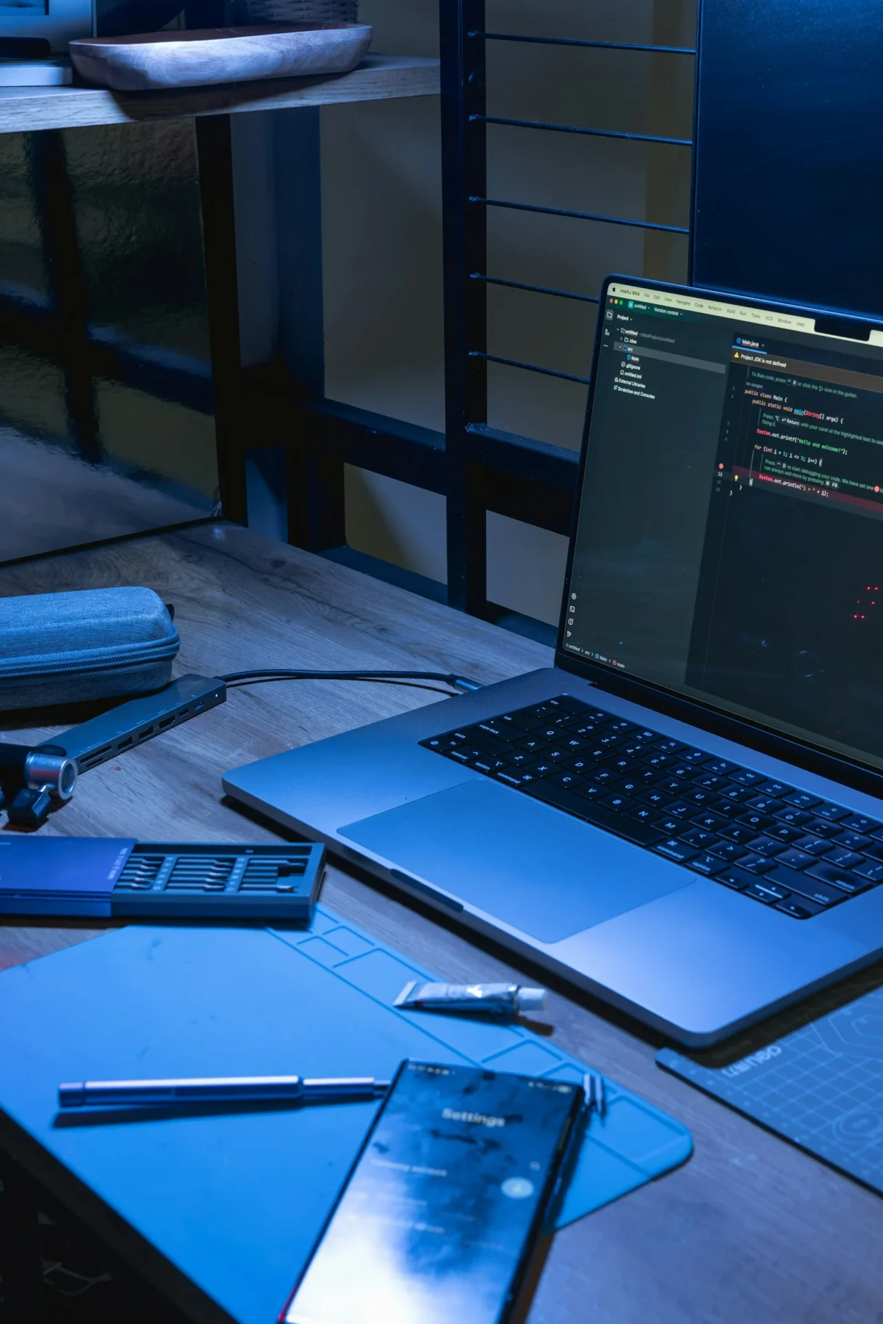 Laptop and phone on a desk with a code editor open